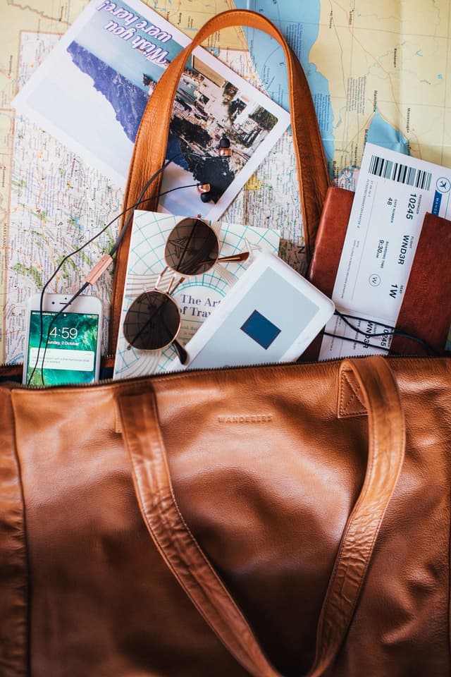 Bolso, mapa, teléfono y accesorios preparados para un viaje